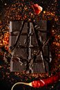 Top view of crushed bar of dark chocolate sprinkled ground relish on dark surface