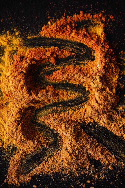 Mix of colorful powdered spices on black background