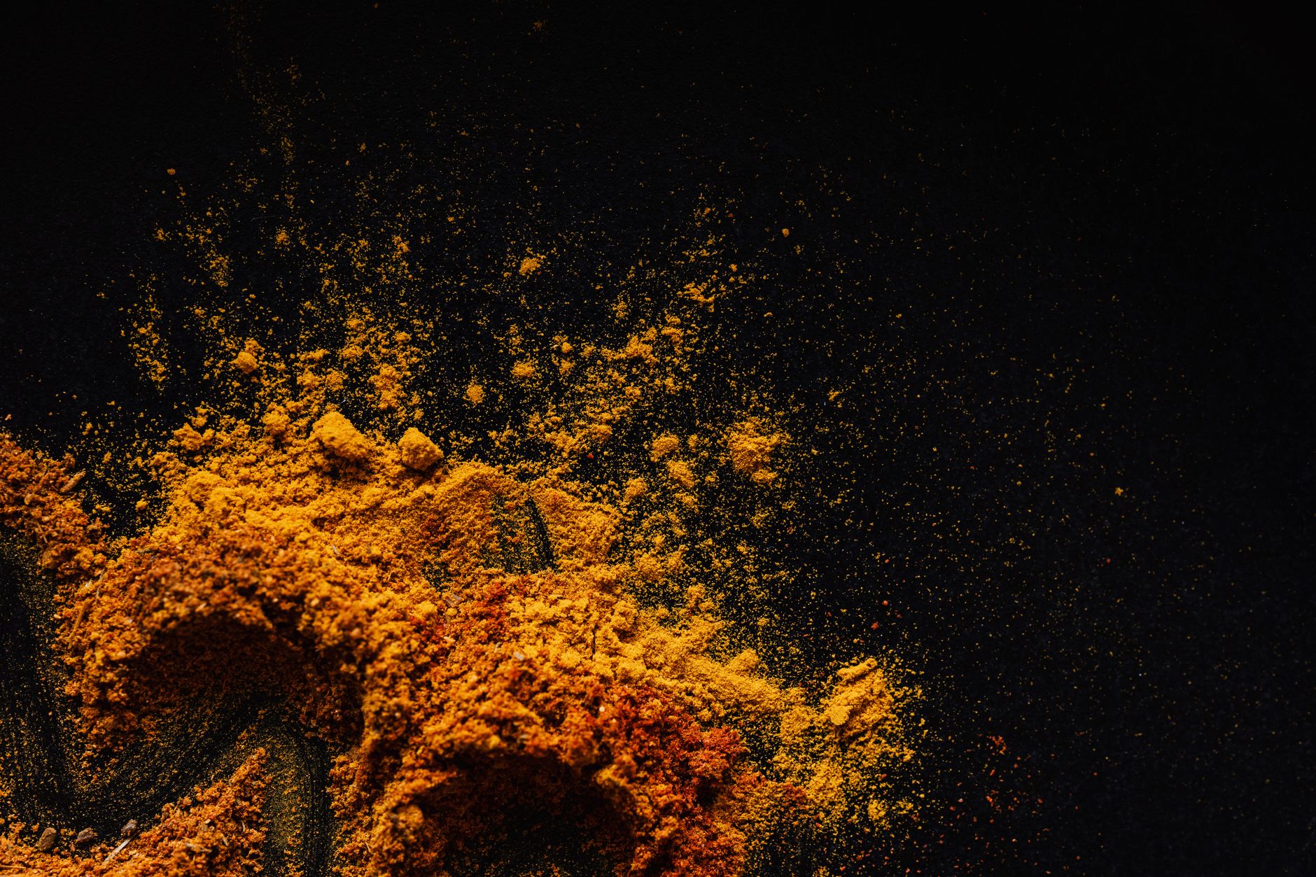 Composition of multicolored ground spices spilled on black background ...