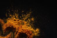 Composition of multicolored ground spices spilled on black background