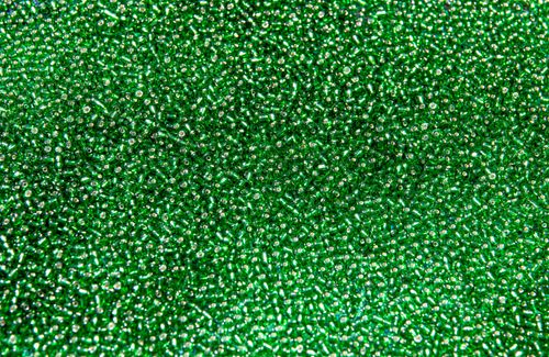 Free A detailed close-up of a heap of sparkling green beads, showcasing texture and color. Stock Photo