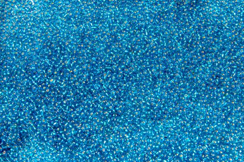 Free Detailed close-up of a pile of vibrant blue glass seed beads, highlighting texture and color. Stock Photo