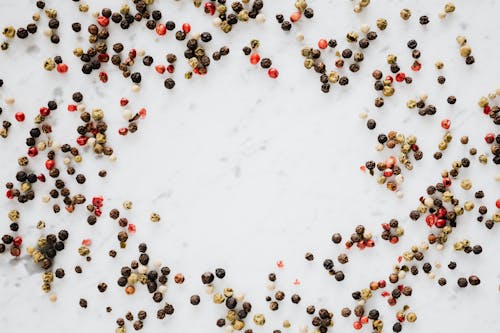 Assorted pepper spilled on white table