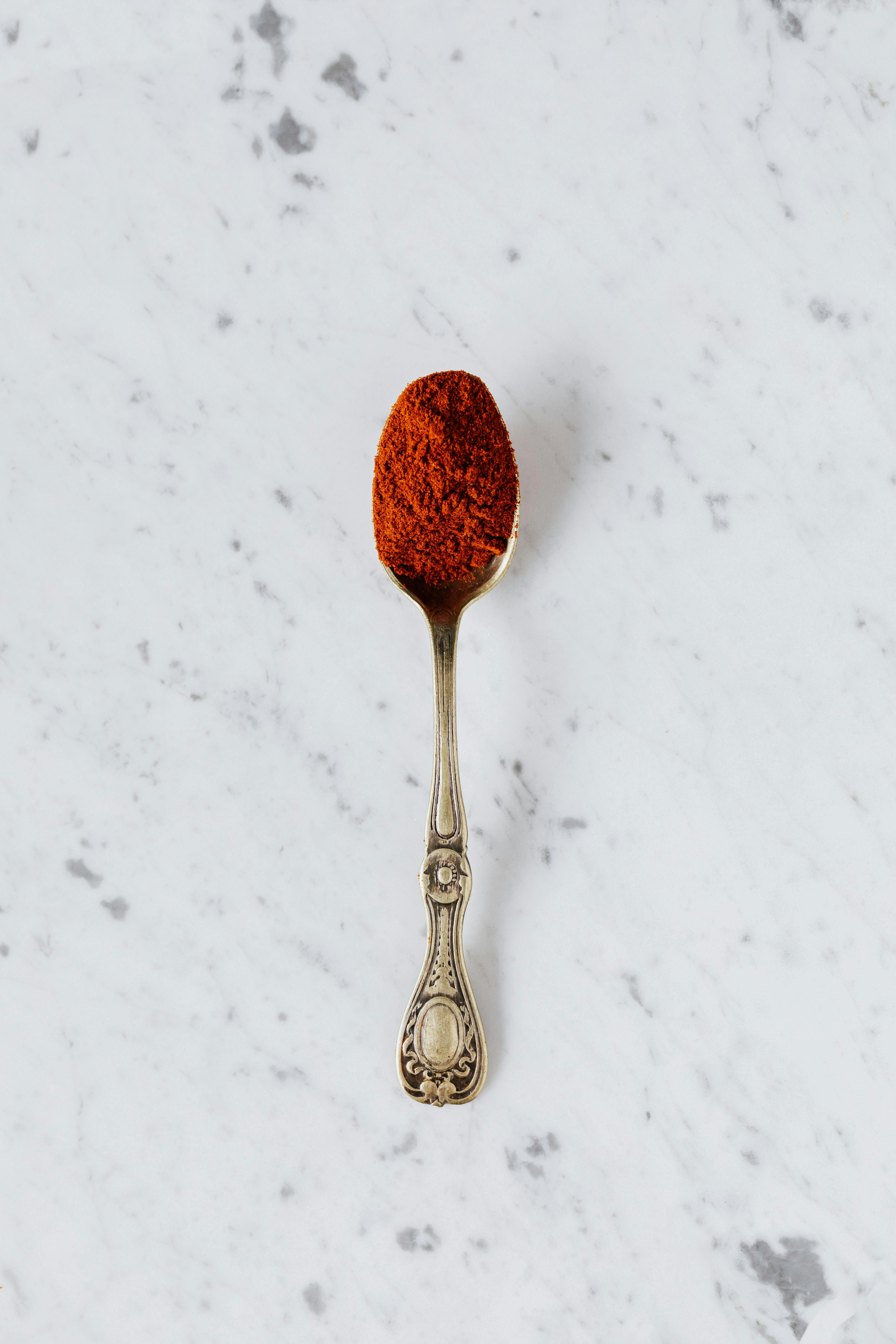 silver spoon with red paprika powder