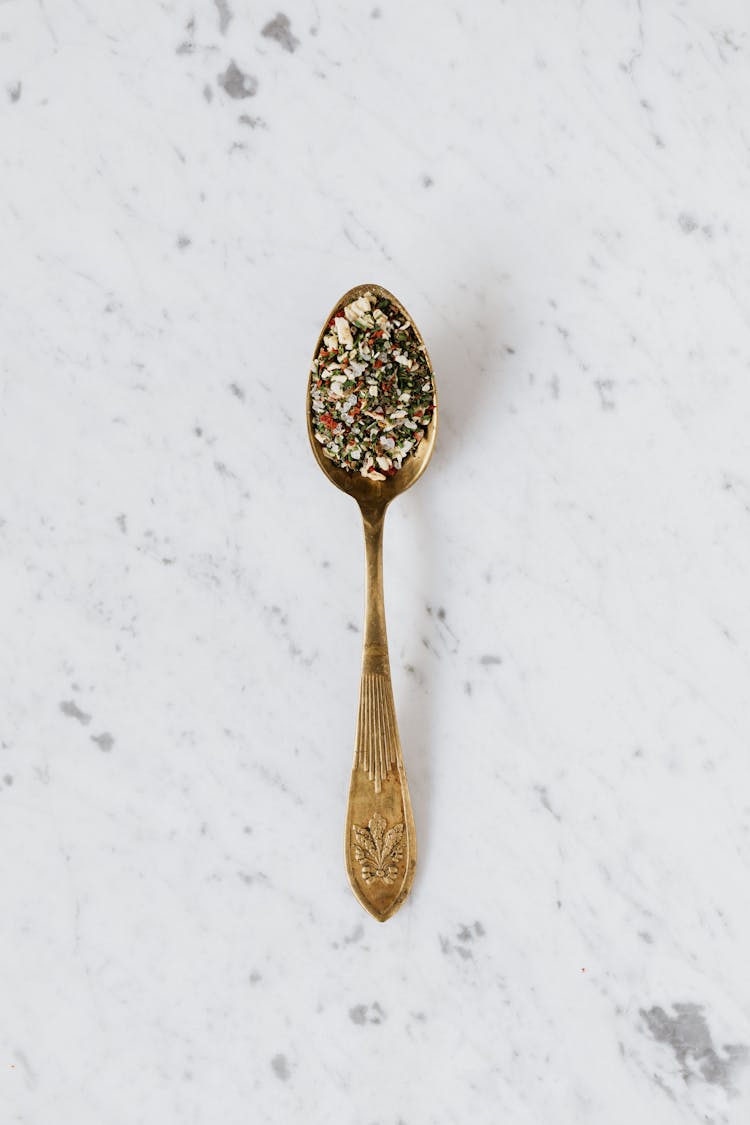 Golden Spoon With Mix Of Herbs And Spices