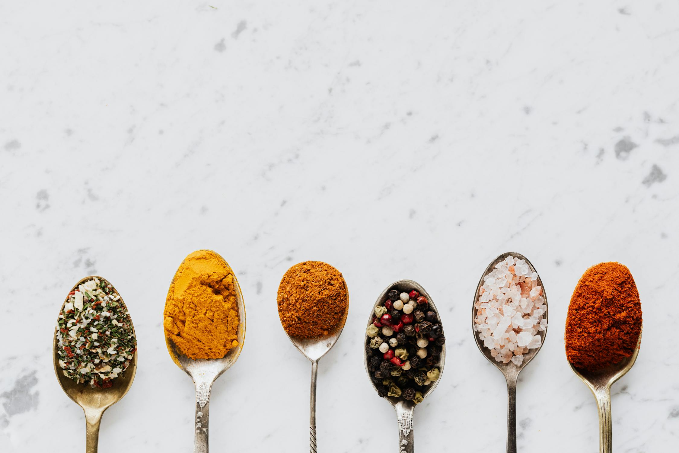 different spices on spoons