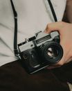 Faceless photographer with old digital photo camera