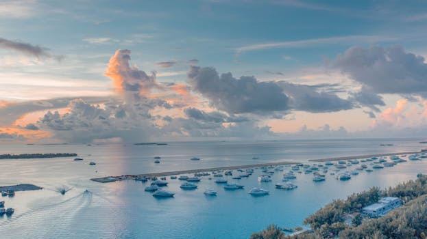 A tranquil sunset view over Malé harbor with boats and clouds in the Maldives.