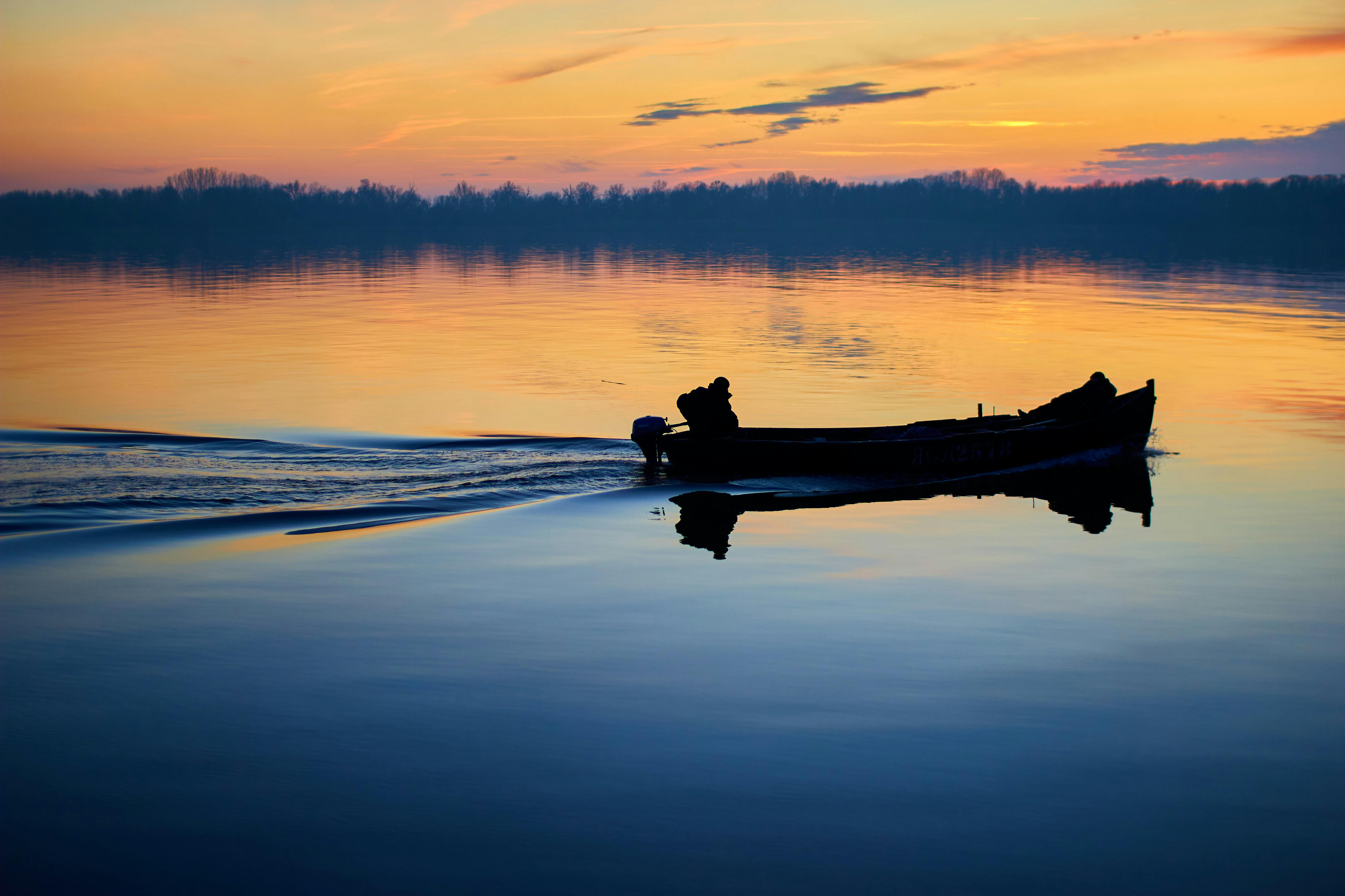 A stunning sunset over Table Rock Lake with a boat silhouette on the water - Missouri boat dealers