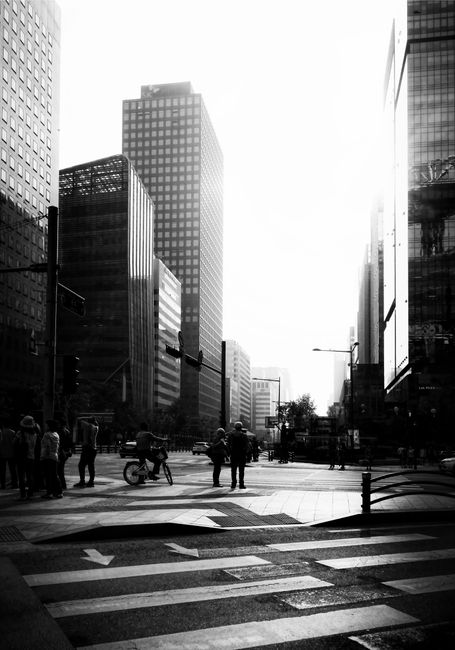 Black and white street view of high-rise buildings and pedestrians in Seoul, South Korea.