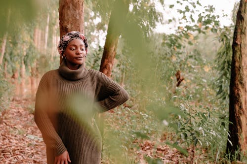 Thoughtful black woman in lush forest