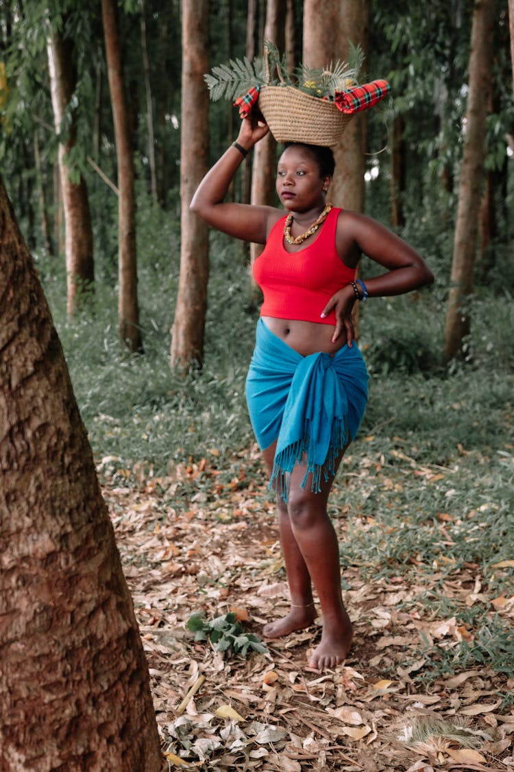 Black Woman Carrying Basket On Head In Park