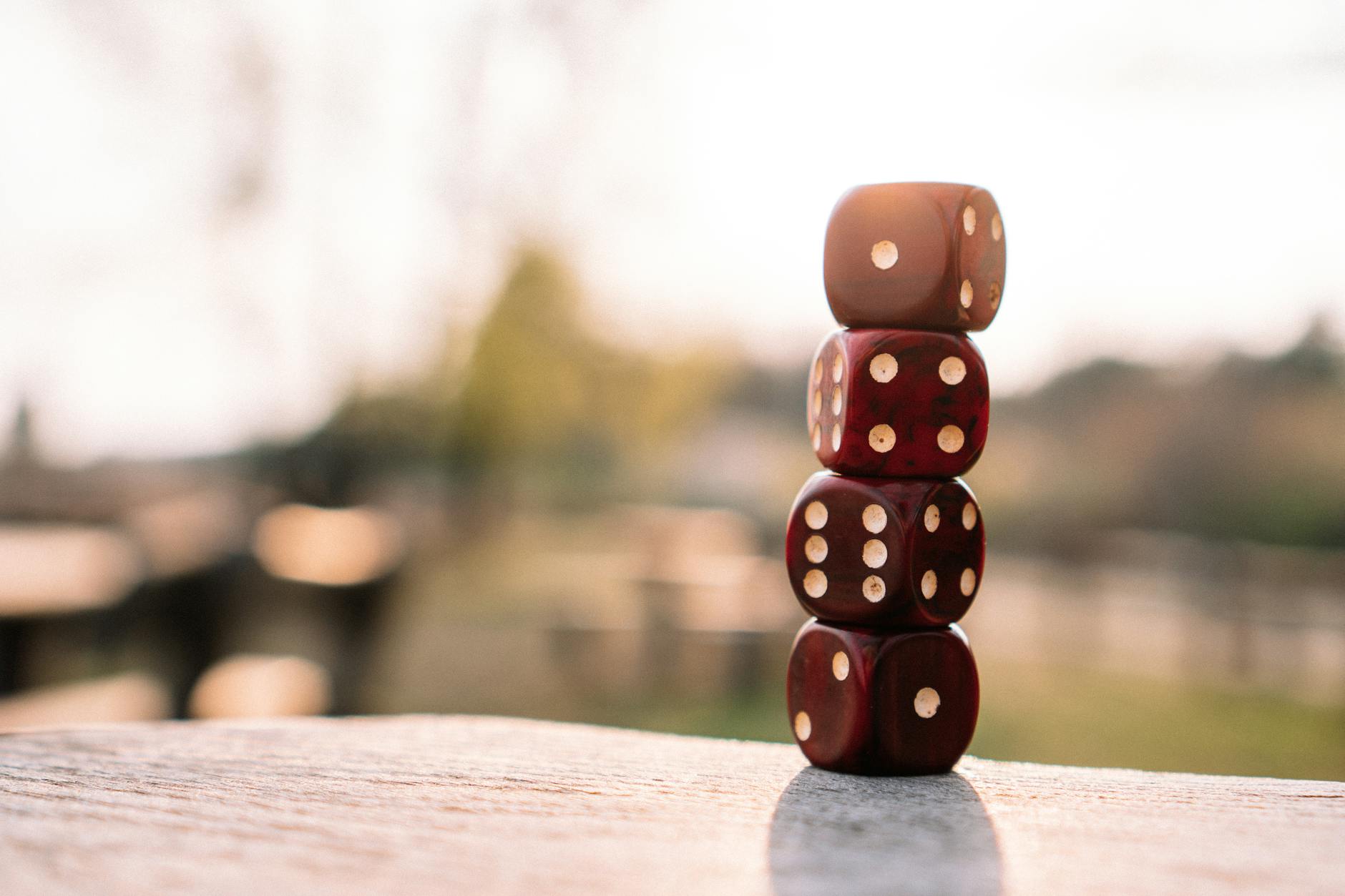 Set of red dice stacked together on wooden table