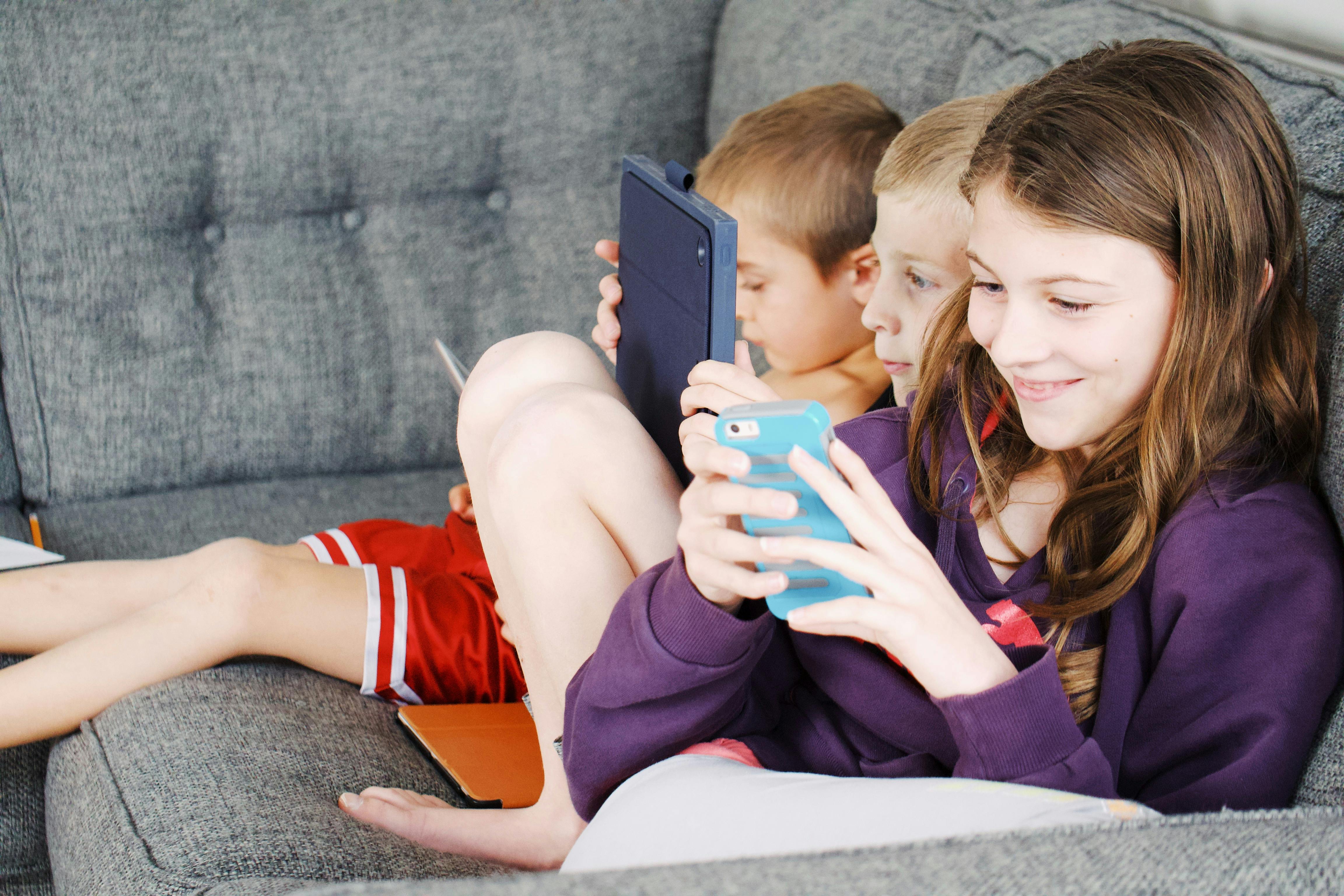Photo of Kids Sitting on Gray Sofa · Free Stock Photo