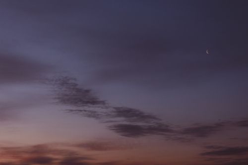 Free From below wonderful scenery of dark late evening sky with light clouds and new moon Stock Photo