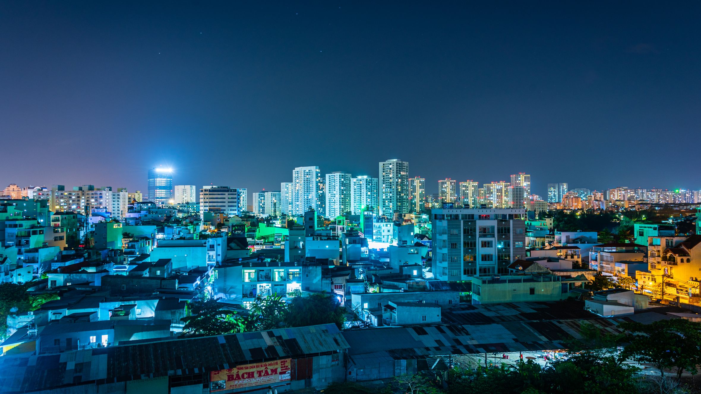 Vibrant night skyline of Hồ Chí Minh City showcasing urban residential and commercial buildings.
