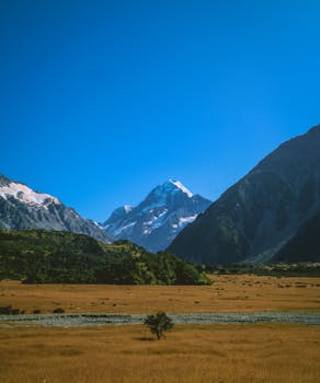 A stunning view of majestic mountains under a clear blue sky in a serene valley.