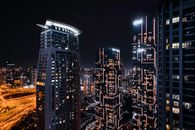 迪拜现代天际线在夜间展现出令人惊叹的景色，灯火通明的摩天大楼与繁华的城市景观交相辉映