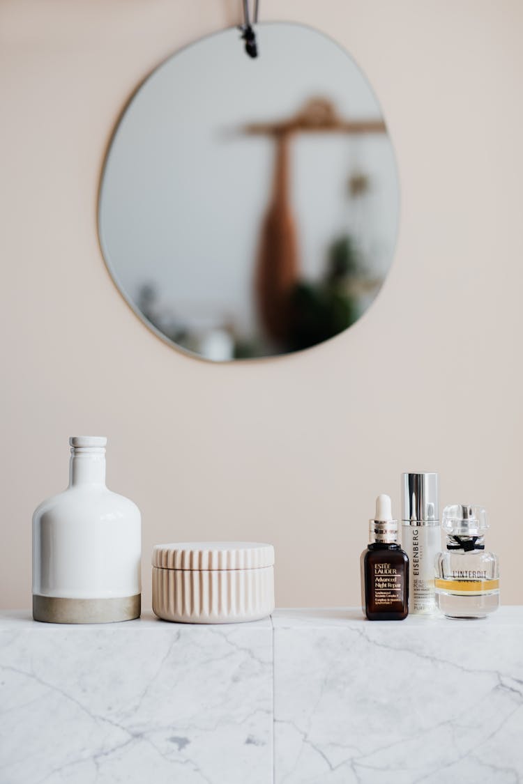 Set Of Cosmetic Products On Marble Shelf In Modern Room