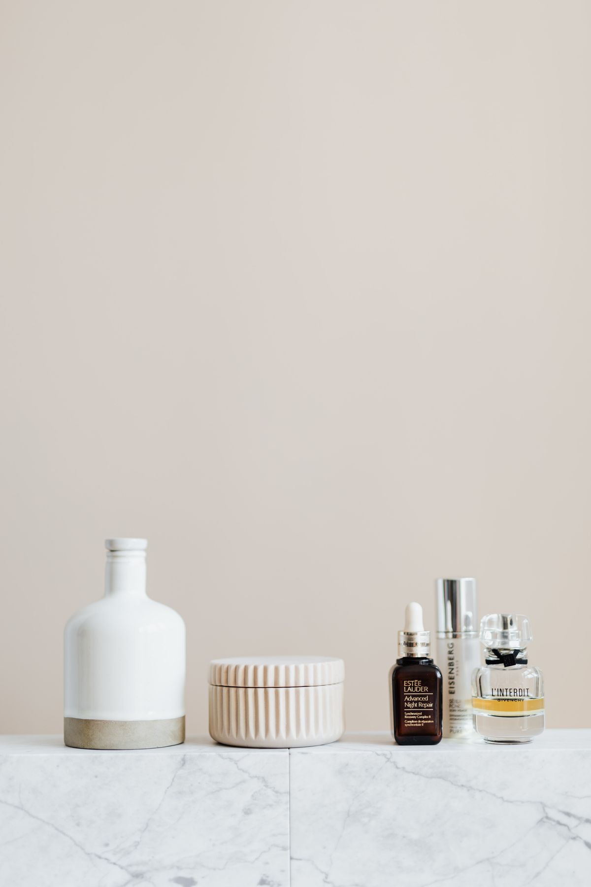 Atelier hand and body ritual bottles on a pale marble shelf