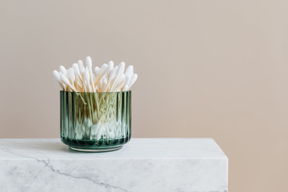 Photo of White Cotton Buds in Glass Container