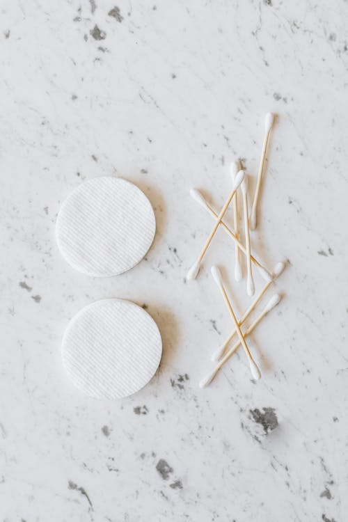 Set of cotton buds and pads on marble surface