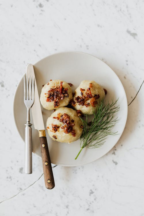 Free Delicious potato dumplings with fried bacon slices on round plate Stock Photo