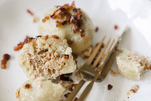 Tasty stuffed dumplings with crispy bacon on a plate, perfect for food photography.