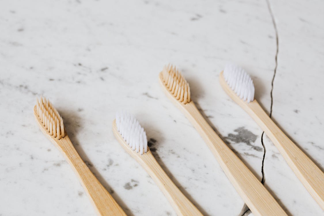 Free Photo of Four Toothbrush on White Surface Stock Photo