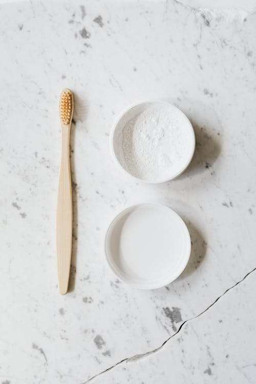 Free Wooden toothbrush and tooth powder on marble Stock Photo