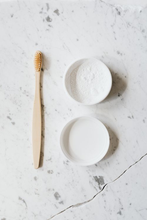 Free Top view layout of wooden toothbrush and tooth powder placed on chipped marble surface of table Stock Photo