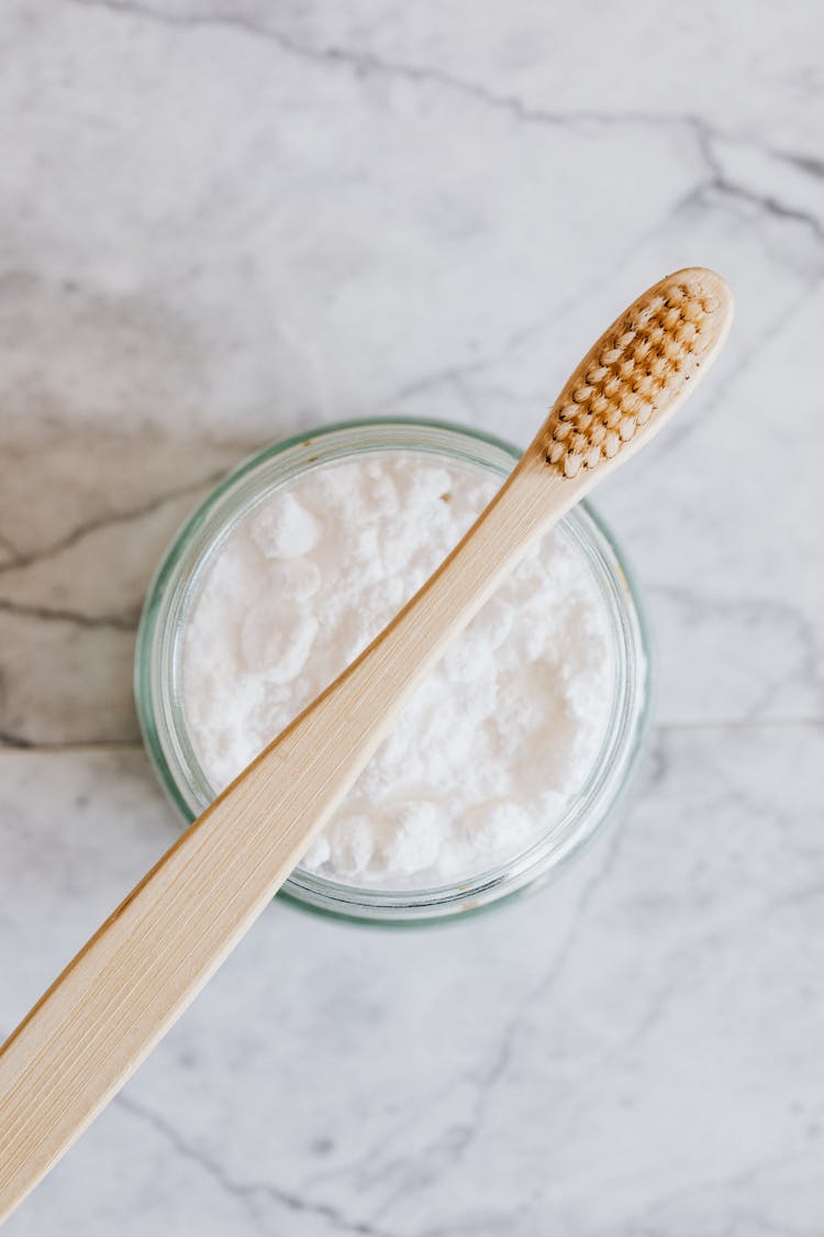 Toothbrush And Jar Of Tooth Powder On Marble