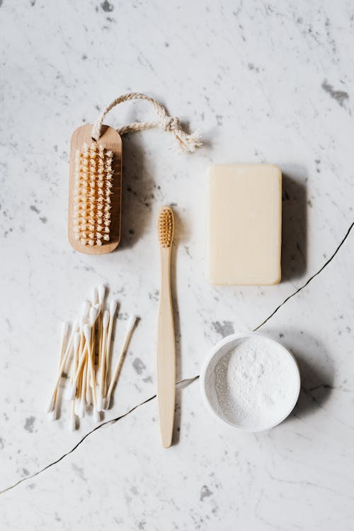 Free Top view composition of wooden cleaning brush and soap and toothbrush and tooth powder and cotton swab placed on marble surface with line chip Stock Photo