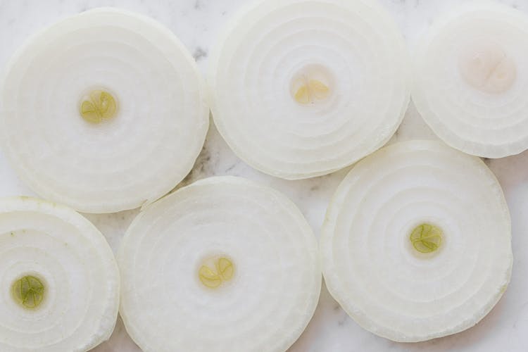 Raw Onion Rings On Marble Surface