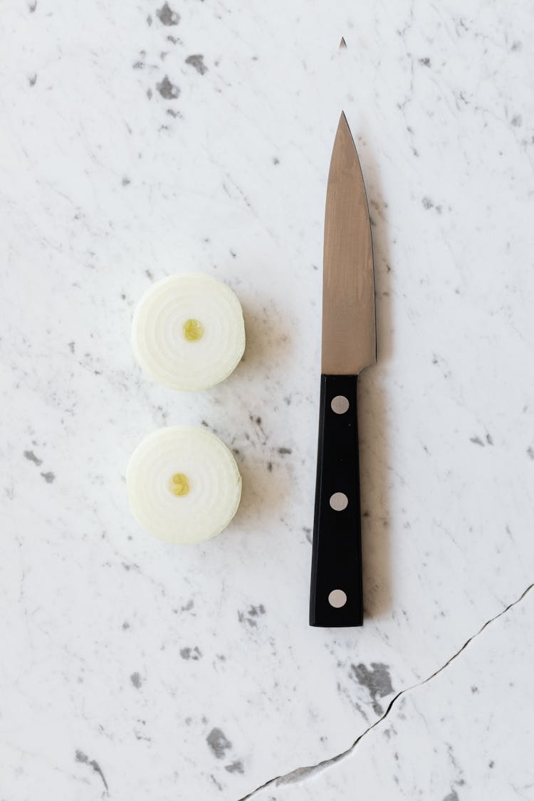 Raw Peeled Onion Cut Into Halves And Knife