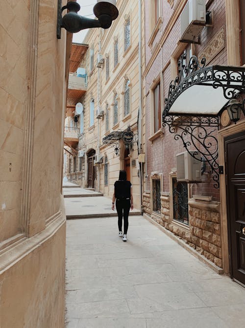 Person Walking Between Buildings