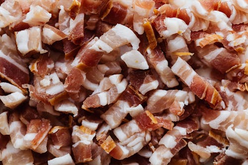 Closeup top view heap of delicious scrumptious pork bellies bacon cut into small slices before cooking process