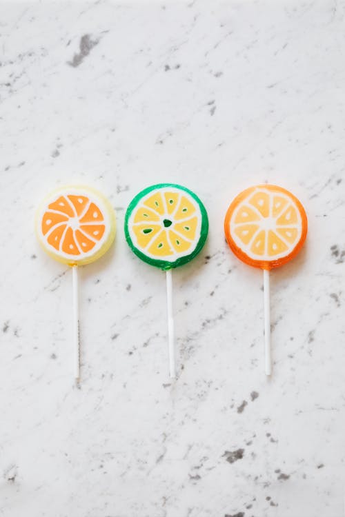 Assorted colorful lollipops on marble surface