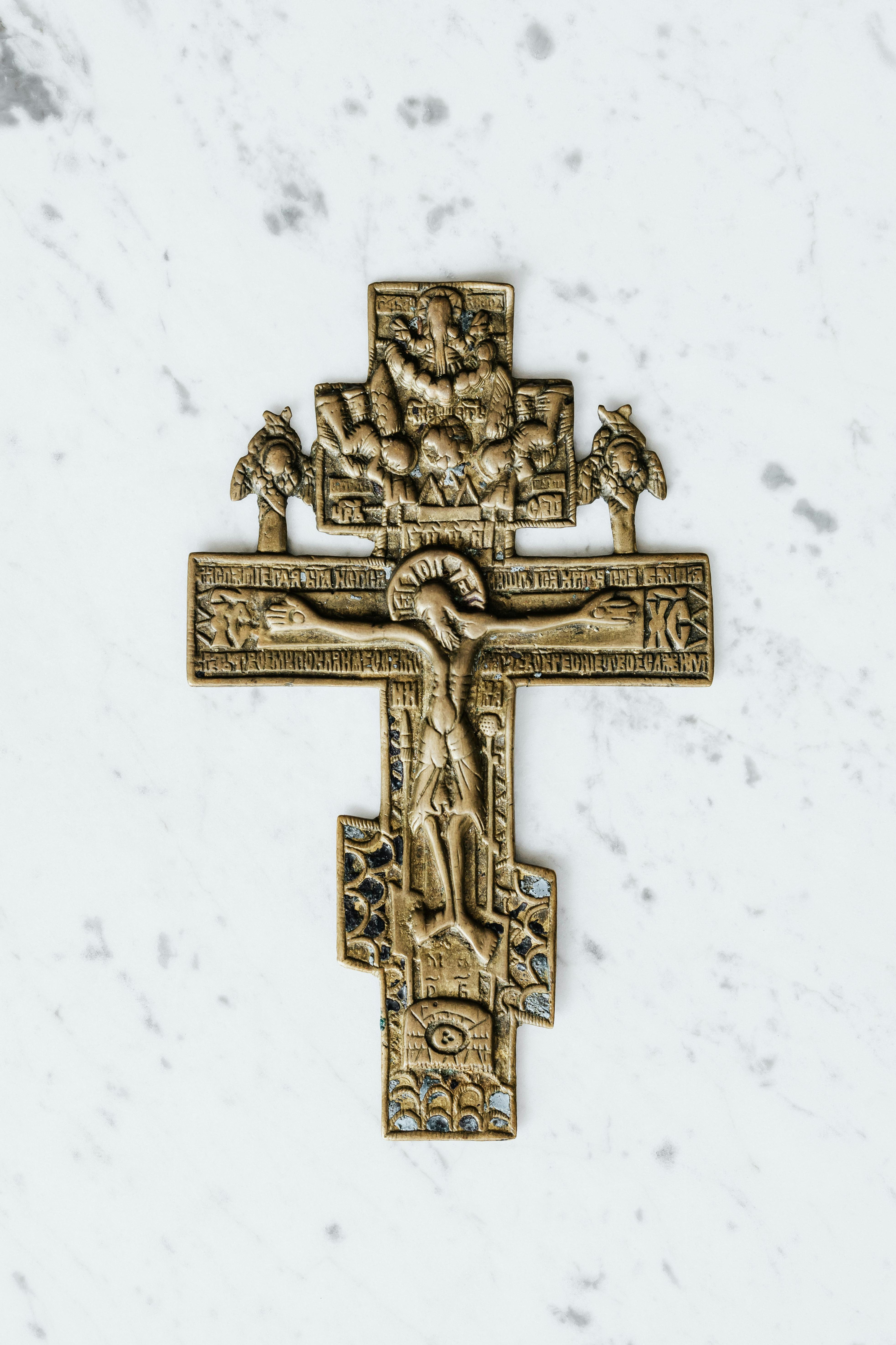 gold cross on white surface