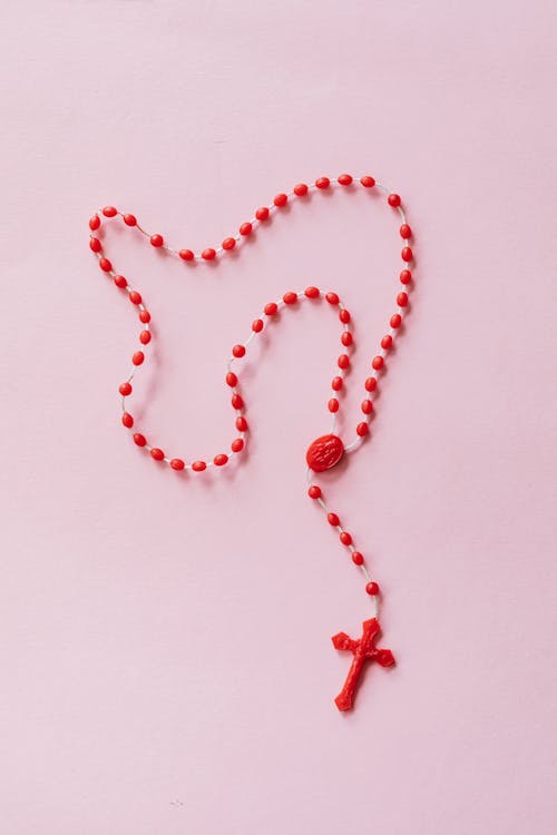 Free Red Rosary on Pink Surface Stock Photo