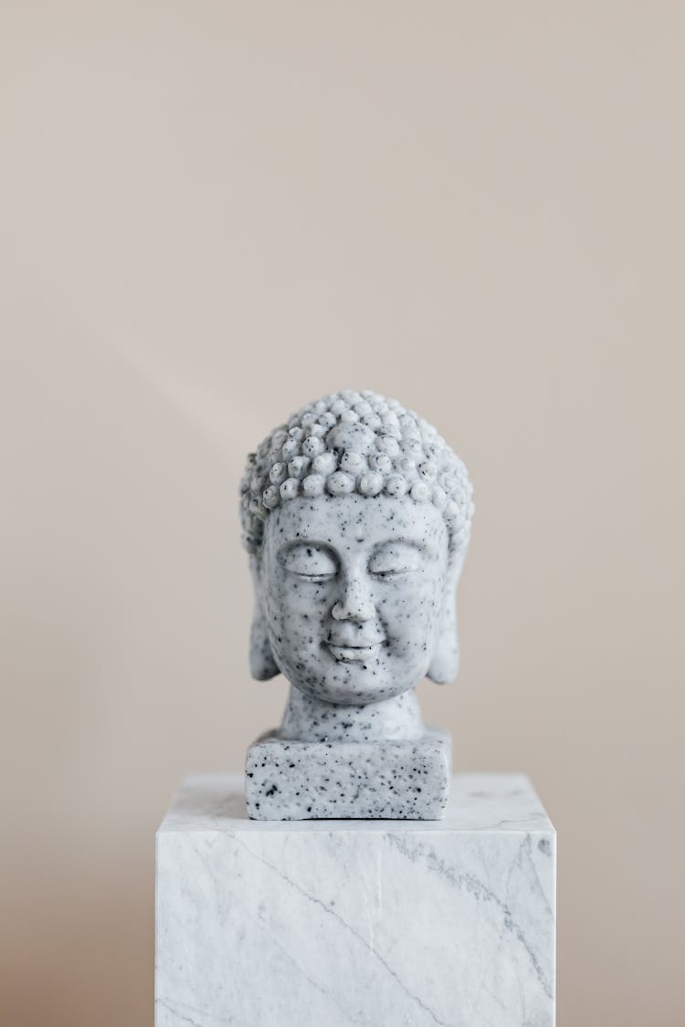 Stone Bust Of Buddha On Marble Stand