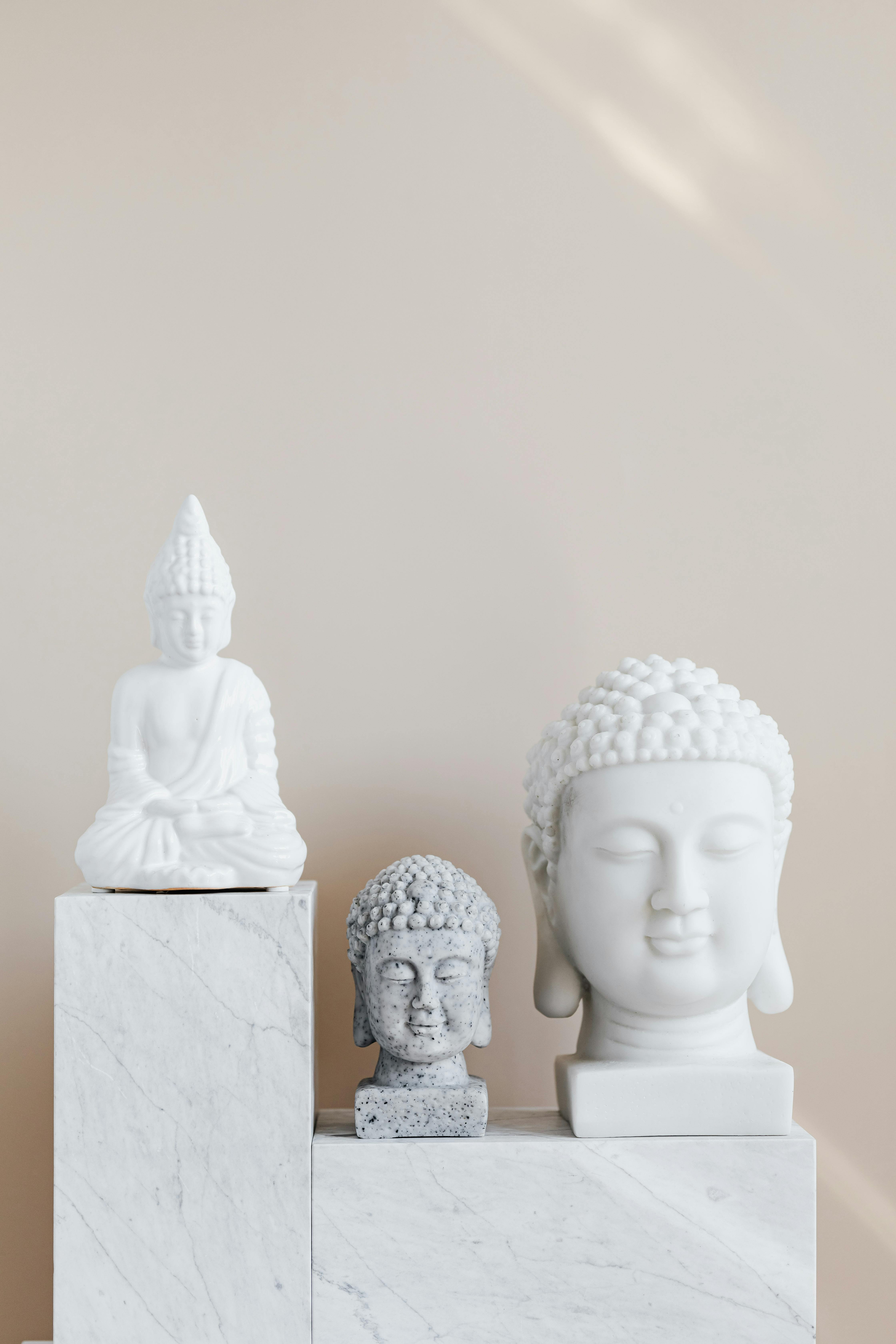 composition of buddha statues on marble stand