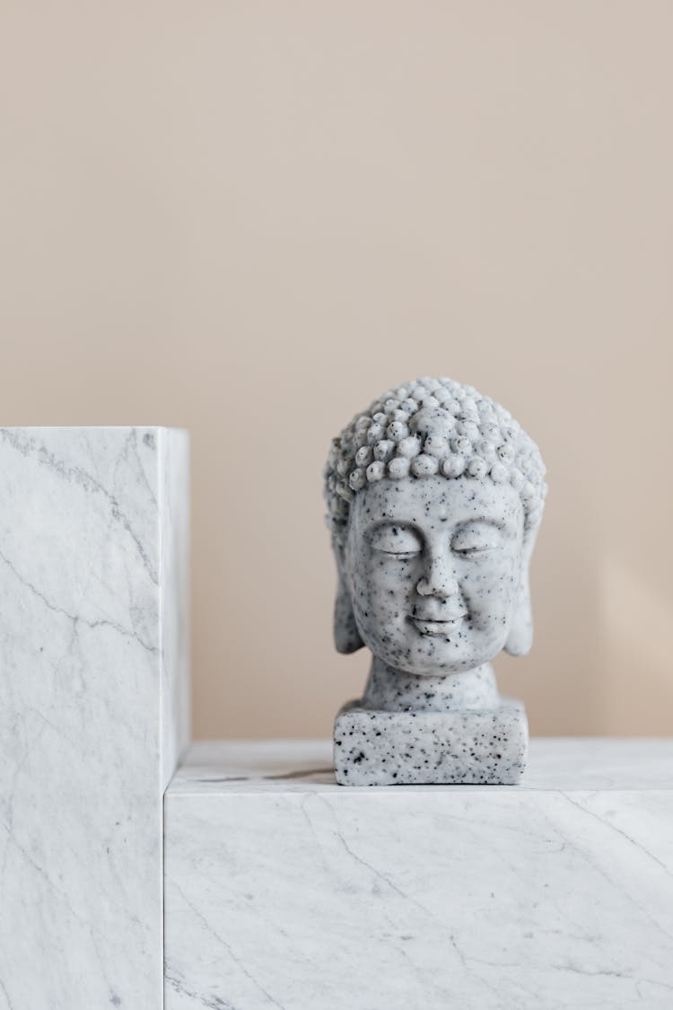 Stone Bust Of Buddha On Marble Shelf