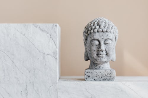 Traditional stone Buddha statue on marble shelf