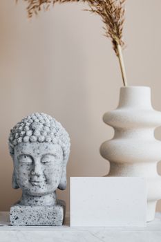 极简主义装饰的特色是佛像雕塑和带有复制空间的现代花瓶