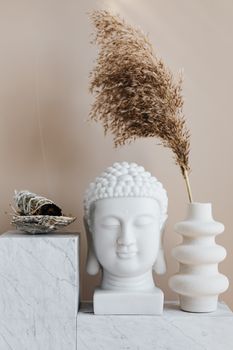 宁静的室内场景中，佛像静立，架子上摆着一个花瓶和鼠尾草