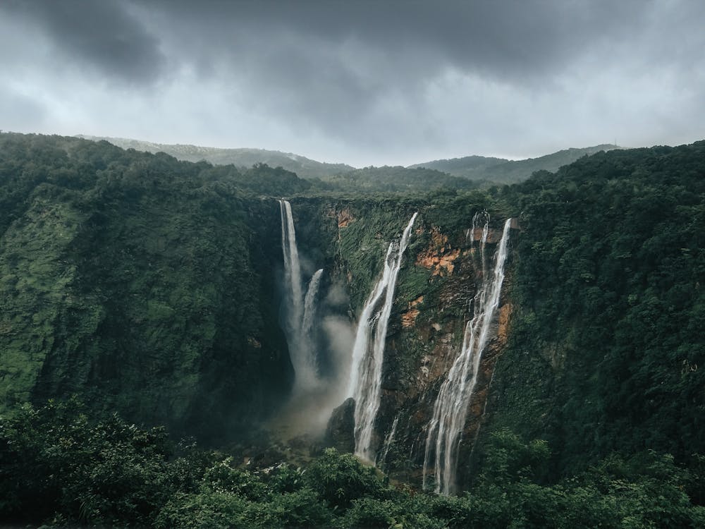 Waterfalls in the Middle of Green Trees Under Gray Clouds