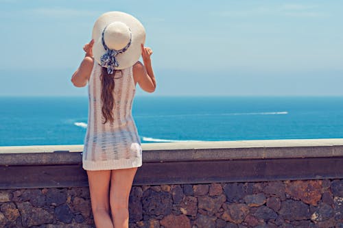 Woman Standing Near Railing Looking on Calm Set