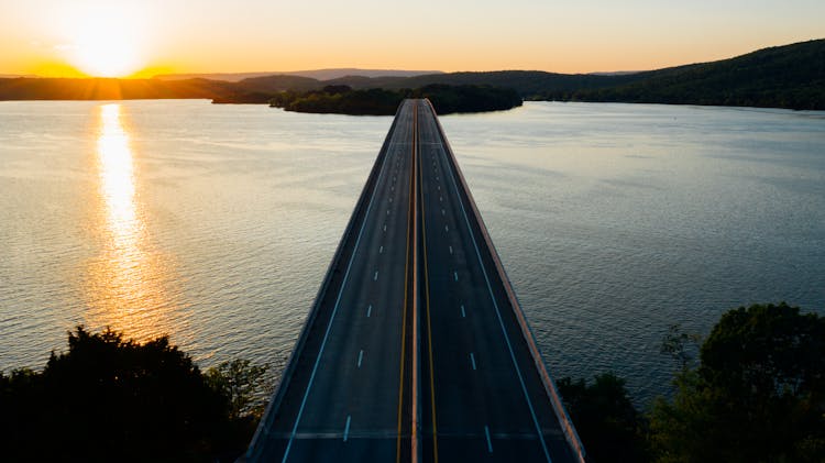 Bridge Over Rippling Lake At Sunrise