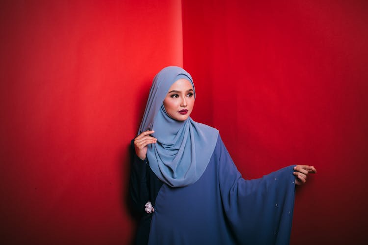 Elegant Young Muslim Lady Looking Away In Red Studio